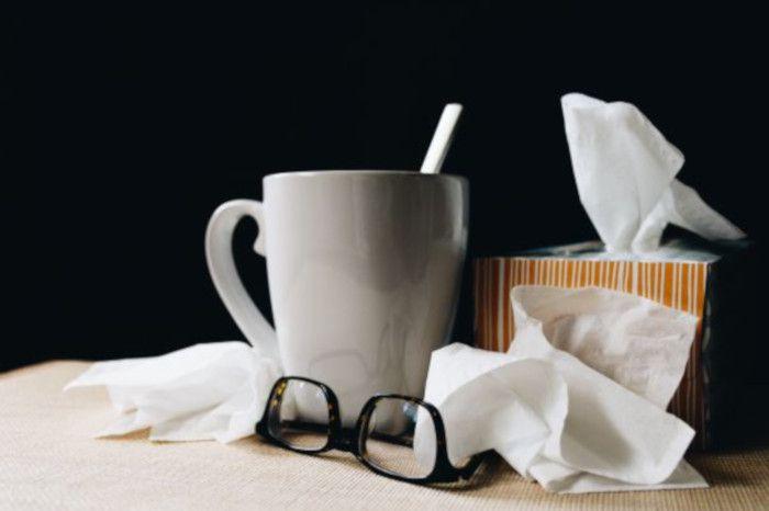 Foto de lenços e caneca de chá como se fosse o equipamento para enfrentar uma gripe