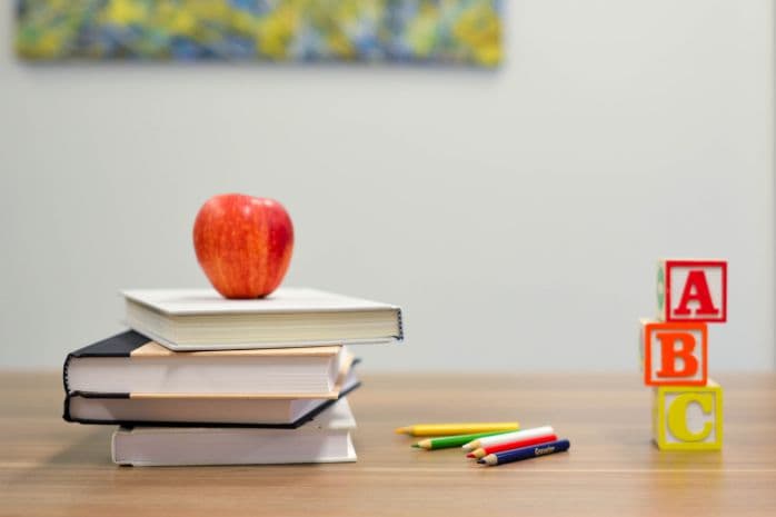 livros e maçã em cima de uma mesa