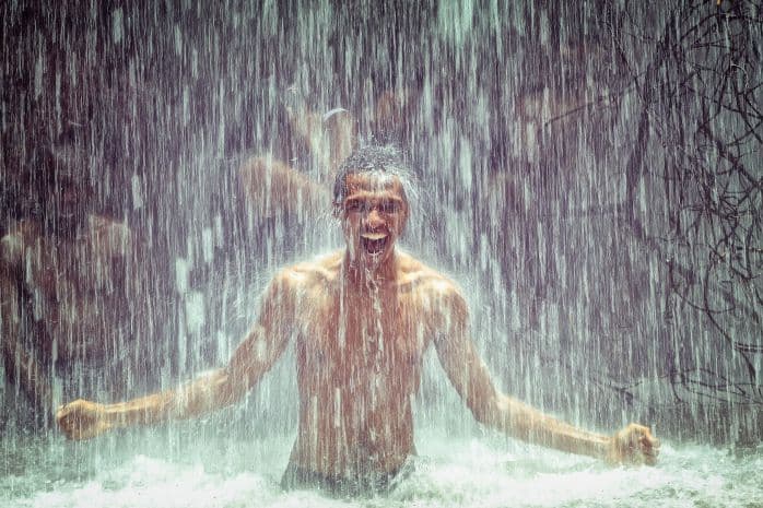 homem tomando banho em uma cachoeira